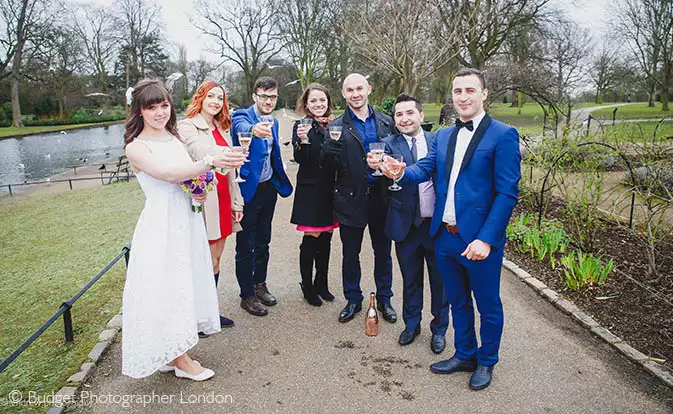 The wedding guests raise their glasses to the happy newly weds