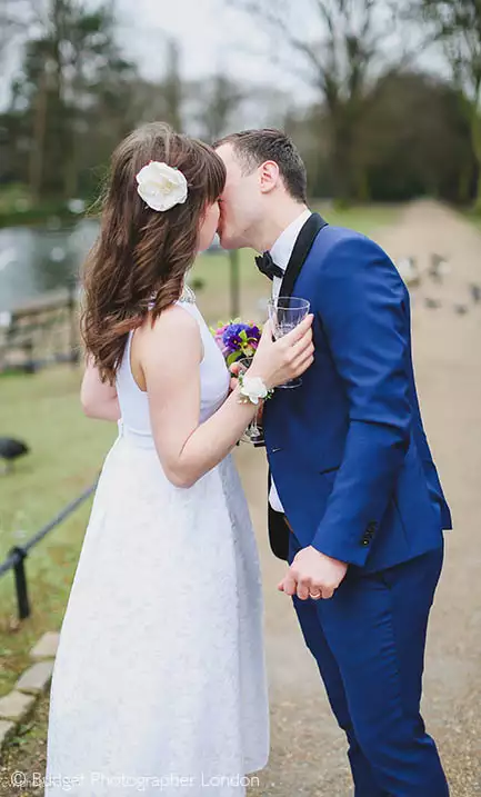 The couple kiss in the park after their civil wedding at the Redbridge registry office